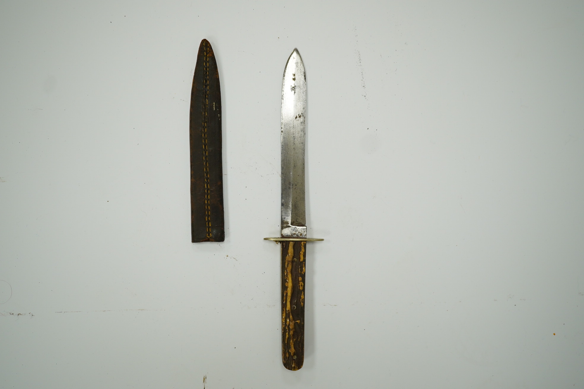 A Hunter of Sheffield, ‘Bugle Knife’ with horn grips, in its leather sheath, blade 15cm. Condition - fair